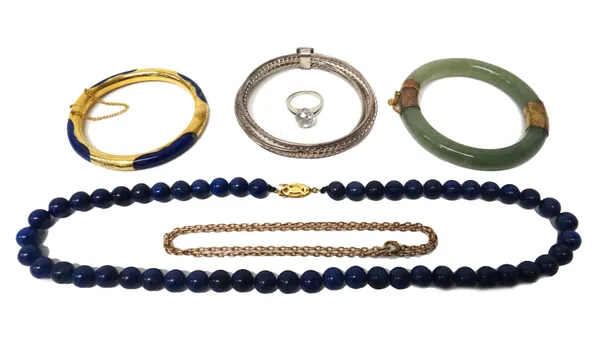 A single row necklace of lapis lazuli beads, on a silver gilt clasp, a gilt metal mounted lapis lazuli bangle, a reconstituted jade bangle, an oval li