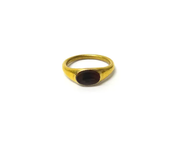 A gold and vary coloured pale brown agate intaglio ring, in the Classical style, the oval intaglio cut as a fish, the ring mount undecorated, gross we