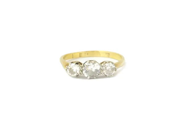 A gold and diamond set three stone ring, claw set with a row of circular cut diamonds and with the principal diamond mounted at the centre, ring size