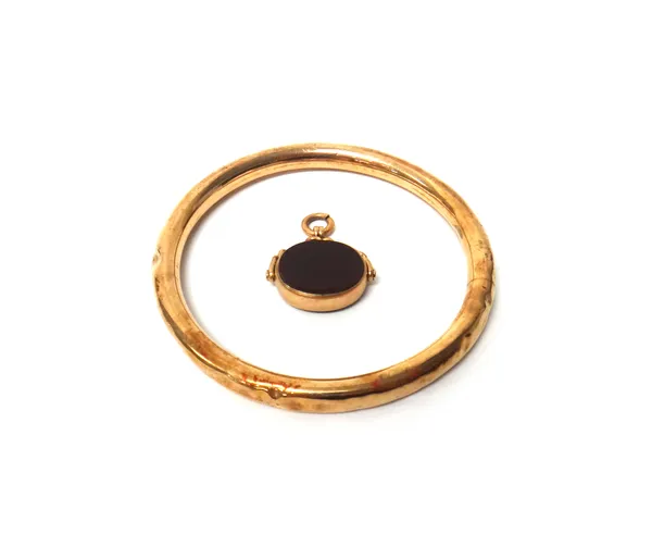 A gold circular bangle, detailed 9 C (dented), gross weight 17.5 gms and a 9ct gold mounted bloodstone and cornelian rotating oval double sided fob se