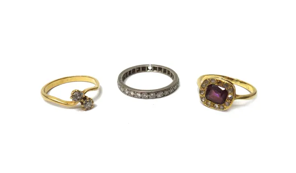 A gold and diamond set two stone ring, claw set with cushion shaped diamonds, in a crossover design, a gold, rose diamond and red gem set cluster ring