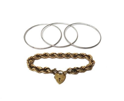 A 9ct gold ropetwist link bracelet, on a 9ct gold heart shaped padlock clasp, fitted with a safety chain, weight 18.7 gms and a set of three silver ci