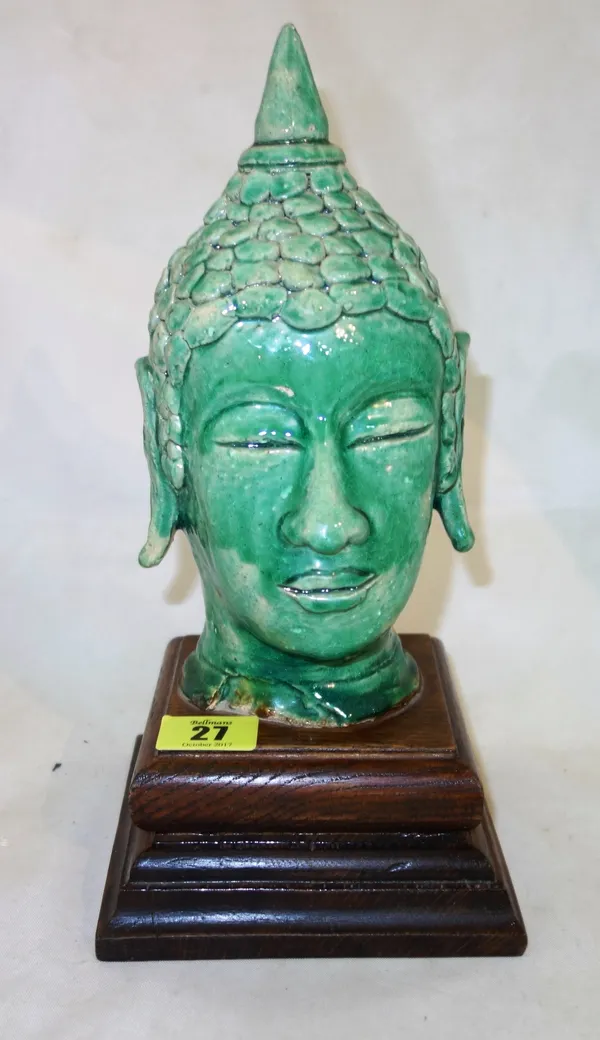 A green glazed head of Buddha, modelled with eyes close and serene expression, mounted on square wood base, overall height 28cm.   CAB