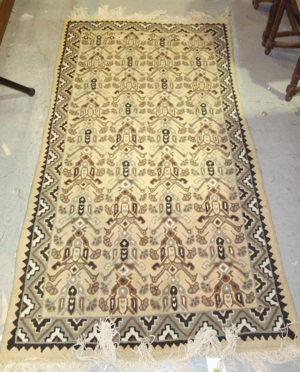 A 20th century rug with beige ground and geometric pattern.    C1