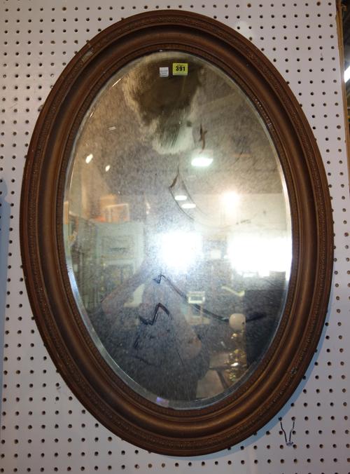 An early 20th century gilt framed oval mirror.   M10
