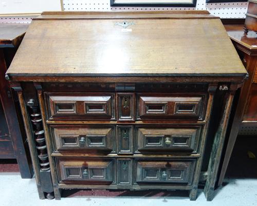 An unusual 17th century oak bureau with turned pull-out lopers and fitted interior over three long geometric moulded drawers, 99cm wide. E10