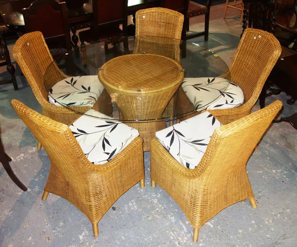 A 20th century wicker conservatory suite, comprising; a circular glass table, 130cm wide x 75cm high, and five chairs, (6).  G7