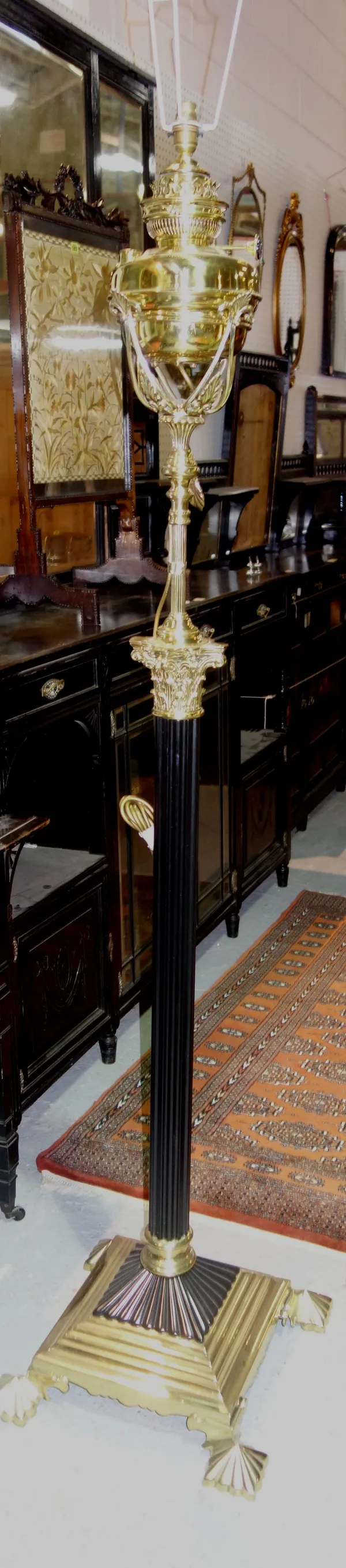 A Victorian style brass and ebonised adjustable standard lamp , of Corinthian column form, with an 'Evereds Victor' oil burner reservoir, all over a t