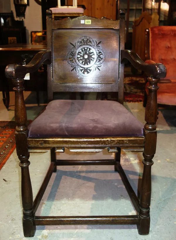 A 17th century style oak armchair, on turned supports, with flowerhead carved back.  J10