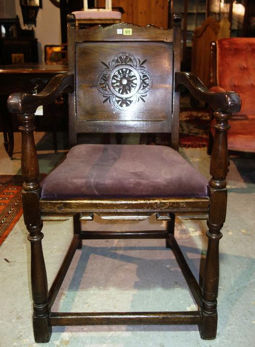 A 17th century style oak armchair, on turned supports, with flowerhead carved back.  J10