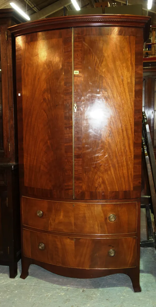 An Edwardian mahogany bowfront two door wardrobe, with two drawer base, 123cm wide.  M8