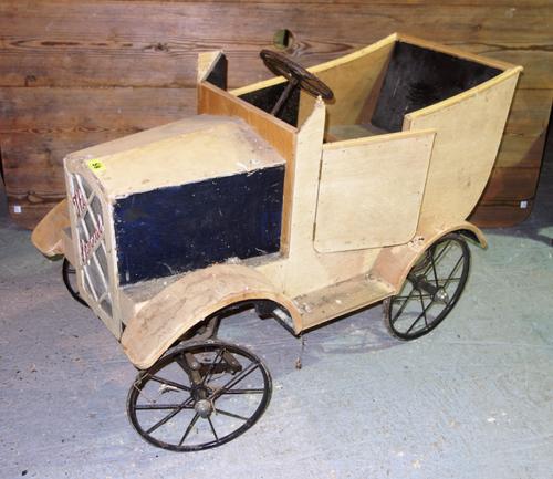A vintage child's wooden toy pedal car.    H7