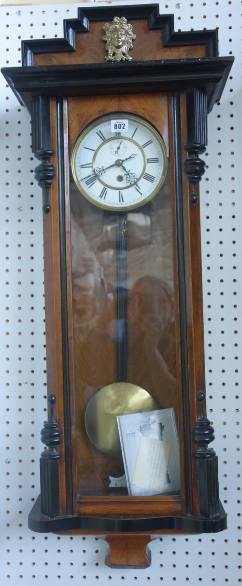 A Vienna cased regulator wall clock, late 19th century, with stepped pediment, enamel dial with subsidiary seconds hand, in a glazed walnut case, 104c
