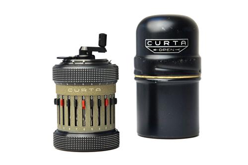 A Curta type II calculator, serial number 522532, made in Liechtenstein, in a cylindrical metal fitted case, 11cm.  Illustrated