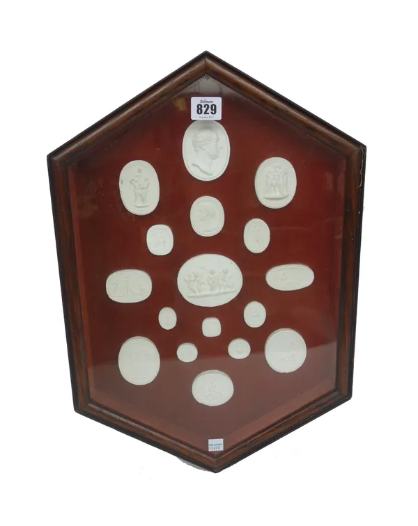 A cased set of seventeen plaster intaglios, 20th century, after the Grand Tour originals, framed and glazed, 48.5cm high.