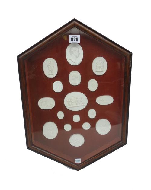 A cased set of seventeen plaster intaglios, 20th century, after the Grand Tour originals, framed and glazed, 48.5cm high.