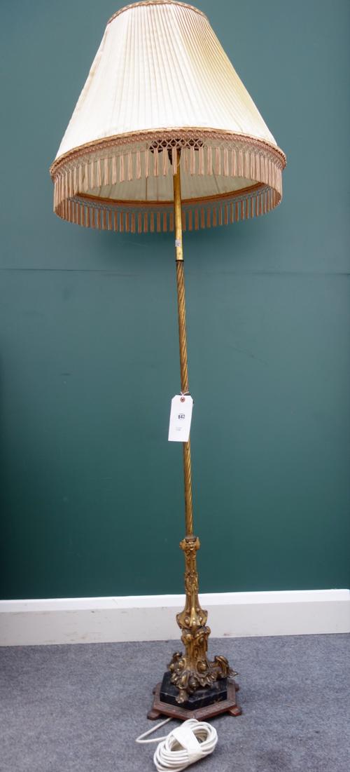 An Edwardian Gothic inspired brass and marble mounted standard lamp, raised on a hexagonal base, with a pleated silk shade.
