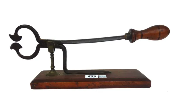 A pair of early Victorian iron and brass sugar cutters, with a turned wooden handle, on a mahogany plinth, 39cm wide.