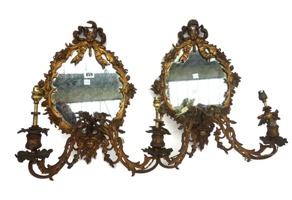 A pair of gilt bronze girandole wall mirrors (converted to electricity), early 20th century, with bow surmount over a foliate cast oval frame, 46cm hi