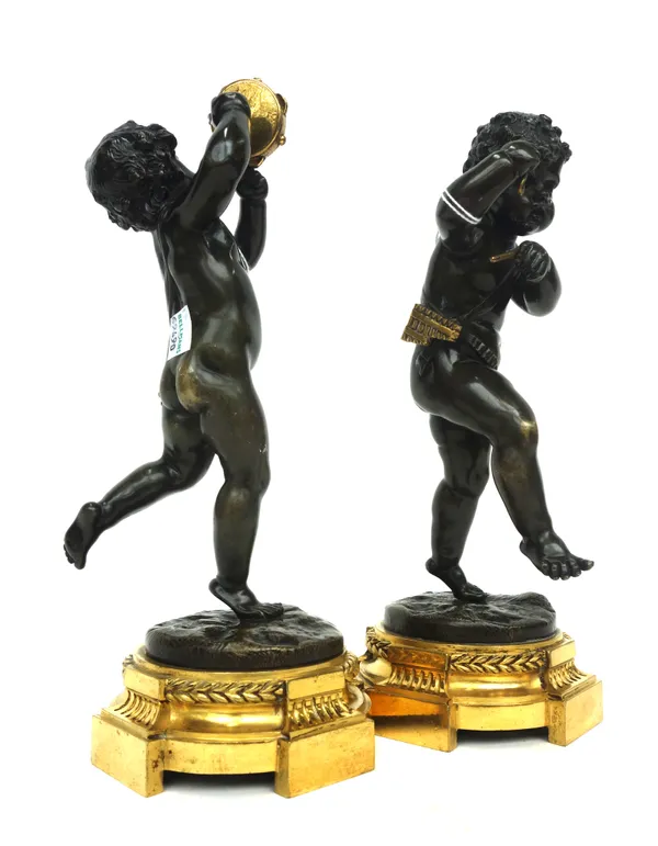A pair of bronze figures of putti, Louis XVI style, 19th century, each holding musical instruments atop a naturalistic base and gilt bronze shaped pli