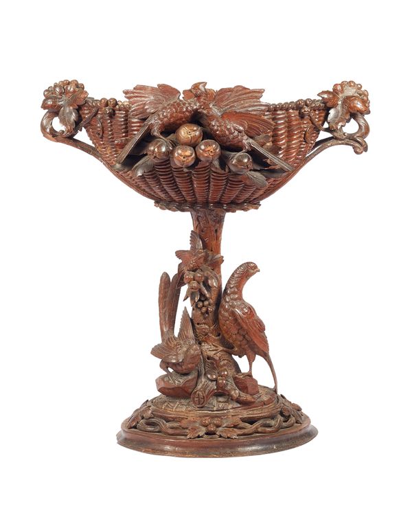 A Black Forest carved wooden jardiniere, late 19th century, the oval basket with foliate handles and applied wildfowl, on a similarly carved oval base