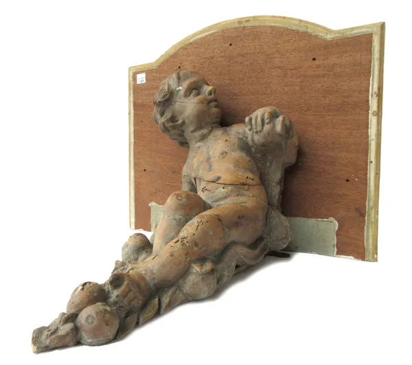A pair of carved pine cherub wall brackets, probably 18th century, with later breakfront 'marbled' wooden top, the cherubs 35cm high, (2).