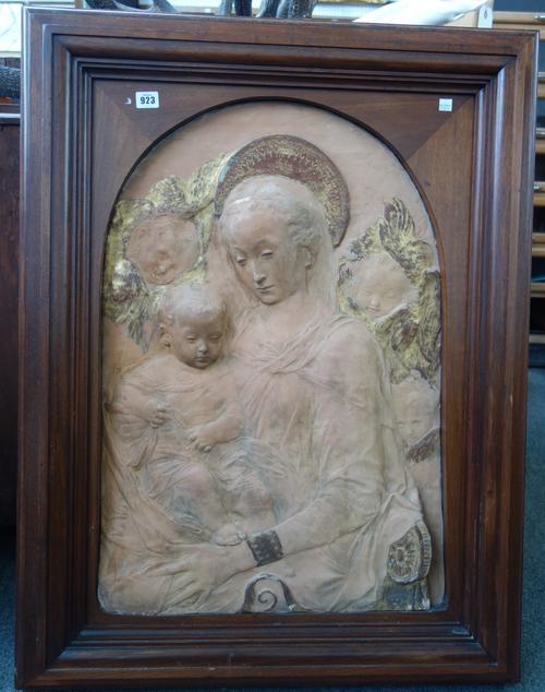 A relief cast terracotta wall plaque, late 19th century, depicting The Virgin Mary and child flanked by angel attendants, gilt heightened and mounted
