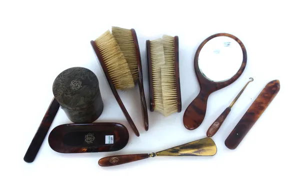 An Edwardian tortoiseshell and brass monogram inlaid part dressing table set, including; an oval hand mirror, two pairs of brushes and further matched