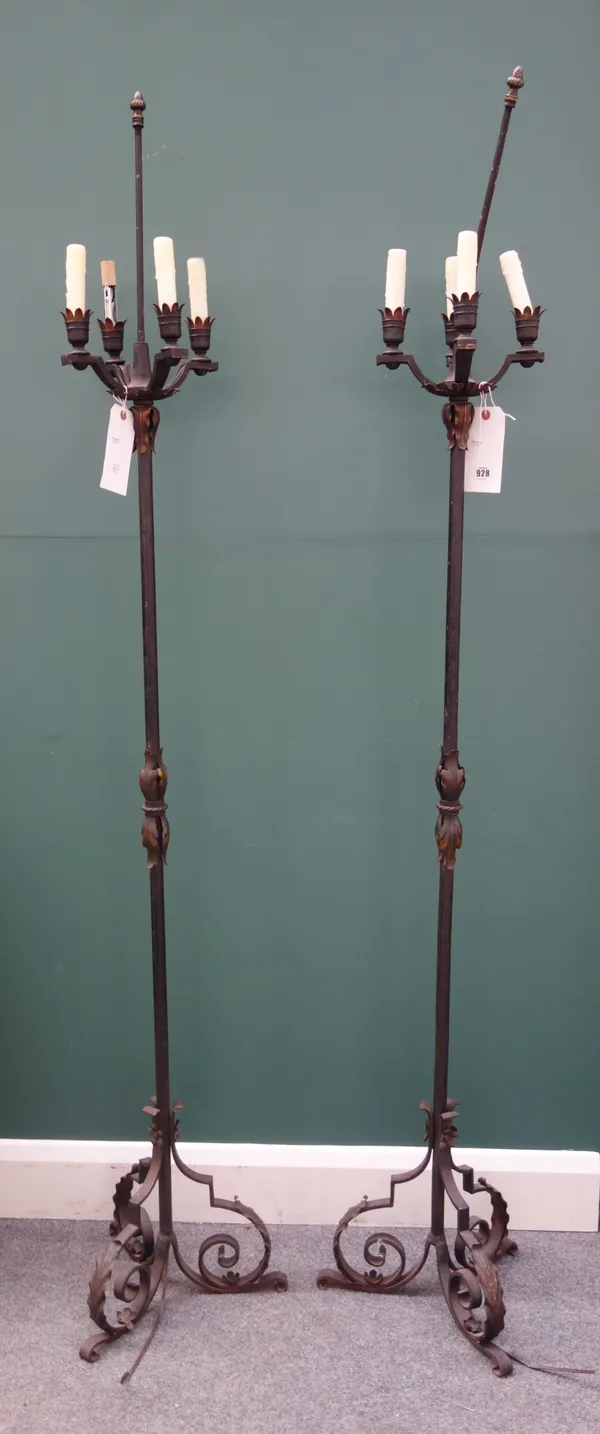 A pair of modern wrought iron four branch candelabra, each with foliate embellishments, on a triform base, 185cm high, (2).
