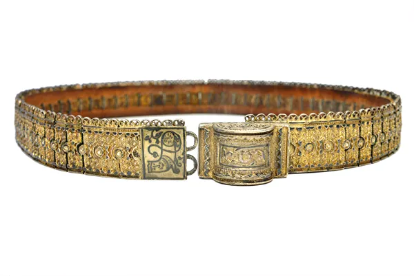 An unusual white metal clad leather belt, 19th century, possibly Persian, of sectional foliate form, 92cm long.  Illustrated