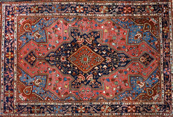 A Mahal rug, Persian, the madder field with a dark indigo medallion, pale indigo spandrels, all with angular vines and flowers, a dark indigo vine and