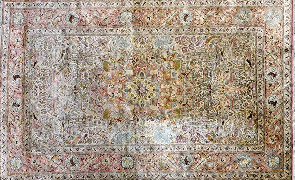 A Turkish silk rug, the ivory field with a central medallion, all with a landscape of trees and animals, a madder complementary border, 207cm x 131cm.