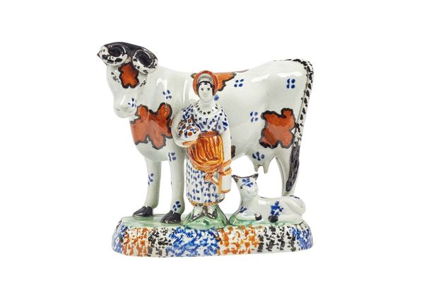 A Pratt ware model of a cow and attendant, circa 1815, with ochre and black markings, a female attendant and calf to the polychrome base, 14.5cm high.
