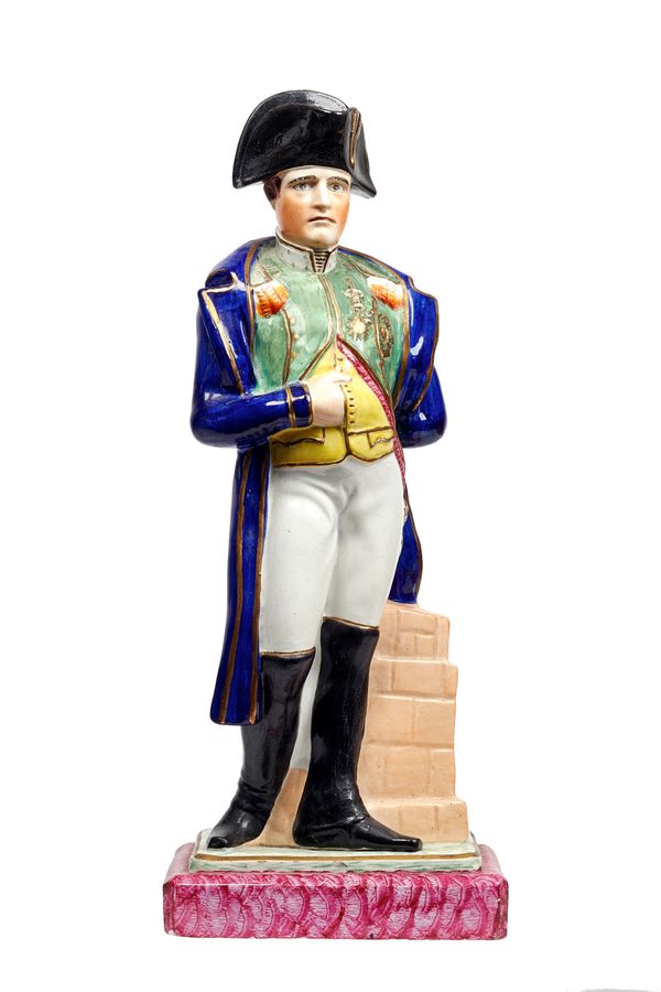 A Staffordshire portrait figure of Louis Napoleon, 19th century, polychrome decorated, modelled standing in typical pose atop a stepped rectangular ba