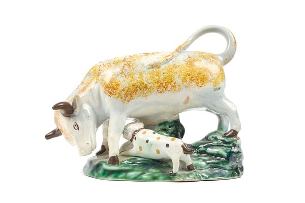 A Staffordshire pottery 'bull baiting' group, early 19th century, sponge decorated in yellows and browns, on a naturalistic shaped base, 15cm high.  I