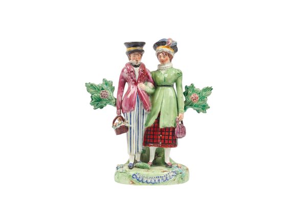 A Staffordshire pearlware figure group 'The Dandies' or 'Dandy and Dandizette', early 19th century, depicting a smartly dressed couple, arm in arm, at