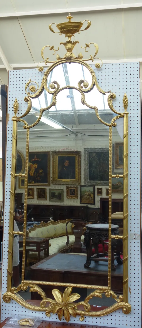 An 18th century style gilt framed wall mirror, with urn crest about the shaped segmented frame, 215cm high x 90cm wide.