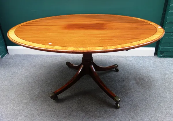 A George III satinwood banded mahogany oval snap top centre table, on turned column and four downswept supports, 153cm wide x 119cm deep.