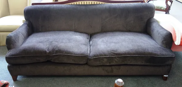 A 20th century brown upholstered three seat sofa, on tapering block supports, 220cm wide x 82cm high.