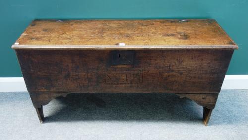 A 17th century oak fine plank coffer with slab end sides, the front panel carved with the initials 'W.H', 127cm wide x 69cm high.