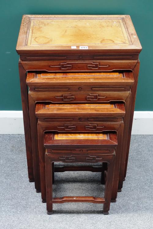 A nest of four early 20th century Chinese hardwood occasional tables, with carved frieze, the largest 48cm wide x 70cm high.