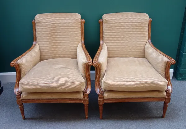 A pair of Louis XVI style beech framed scroll back arm chairs, on tapering fluted supports, 79cm wide x 98cm high, (2).