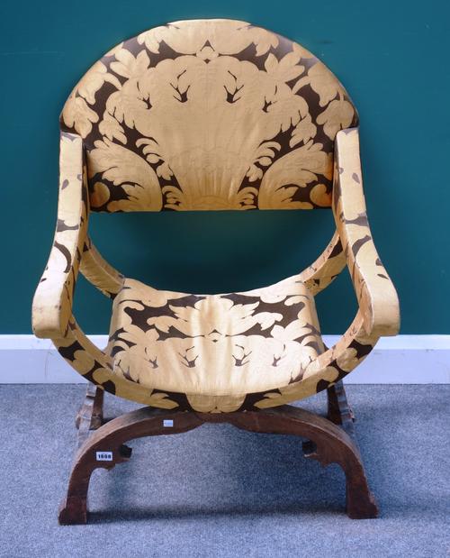 An early 18th century French semi-upholstered beech open arm X-frame chair, with hump back, 63cm wide x 94cm high.