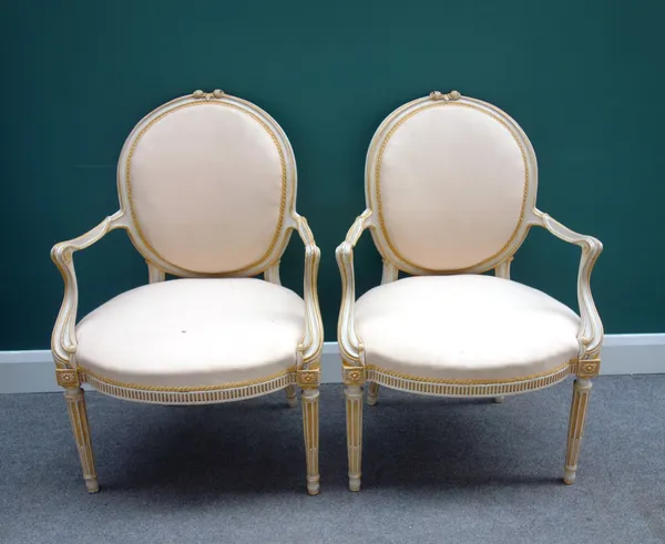 A pair of 18th century North European cream painted and yellow highlighted open armchairs, with oval back and bow seat, on tapering fluted supports, 6