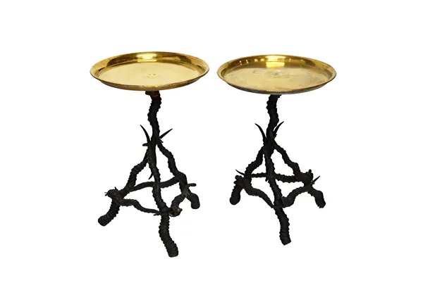 A pair of occasional tables, each with circular brass tops, on gazelle antler tripod bases, each 28cm wide, 56cm and 54cm high, (2).  Illustrated