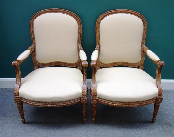 A pair of Louis XVI style open arm chairs with bow seat on fluted supports, 70cm wide x 103cm high.