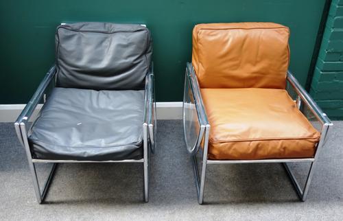 A set of three 20th century polished tubular armchairs, with semi-elliptic drop-flap sides, each 66cm wide x 75cm high, 139cm wide open, (3).