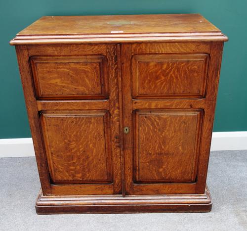 A late Victorian oak canteen cupboard, the pair of double panel doors enclosing five long graduated drawers, on plinth base, 100cm wide x 99cm high, t