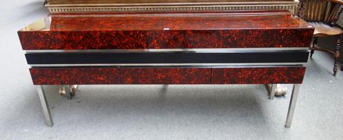 20th century design; a faux tortoiseshell sideboard, with lift top over three drawers, on square polished steel supports, 184cm wide x 77cm high.