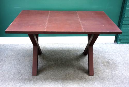 Dominic Chambon, Paris; a 20th century tan leather veneered rectangular table, on X-frame supports, 130cm wide x 76cm high.